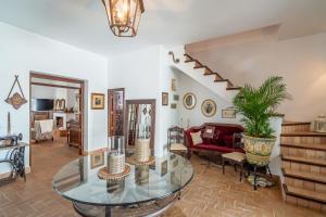a living room with a glass table and a staircase at Casa rural Pozo Viejo in Marchena