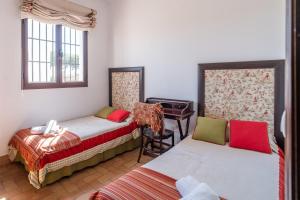 a room with two beds and a piano at Casa rural Pozo Viejo in Marchena +42 photos