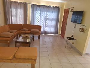 a living room with a couch and a table at Ehenye Villa in Oshakati