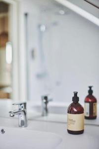 a bottle of soap sitting on a bathroom sink at Bris Apartments in Haugesund +16 photos