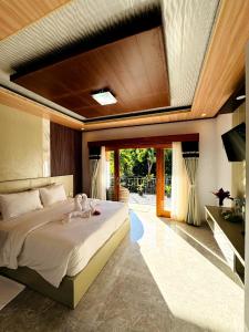 a bedroom with a large bed with a ceiling at Coral Bay Bungalows Amed Bali in Amed