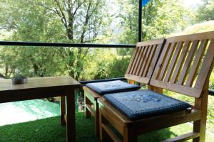 a wooden bench sitting on a porch with a table at The tented tribe in Dharamshala