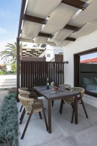 ネア・ローダにあるBlue Whisper Luxury Living Suitesのパティオにある木製のテーブルと椅子