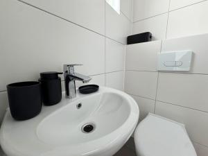 a white bathroom with a sink and a toilet at Fabulous House in Wesseling in Wesseling +20 photos