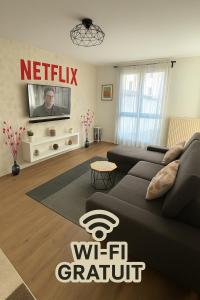 CourcouronnesにあるEden suiteのソファとテレビのあるリビングルーム