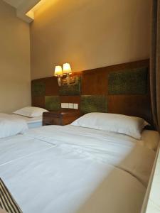 Postel nebo postele na pokoji v ubytování Beijing Huiqing Garden Bussiness Hotel