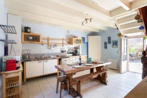 une cuisine avec une table en bois dans une pièce dans l'établissement Ker Aventin - Jolie maison classée 3 étoiles, à Pléneuf-Val-André 8 autres photos