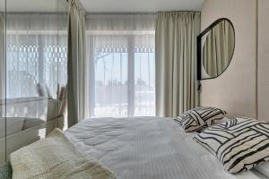 una camera da letto con un letto con uno specchio e una finestra di GRANO APARTHOTEL Ustronie Morskie a Ustronie Morskie Altre 81 foto