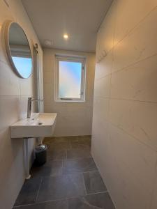 a bathroom with a sink and a mirror at Pure Wellness Bungalows 121 Sauna&Massage&Hottub in Ewijk +63 photos