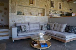 a living room with a couch and a table at Oliva Emerald Eco - Secluded Off-Grid Vineyard Villa in Káto Váthia
