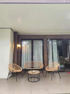 a patio with a table and chairs and windows at Five Leo’s villa in Gadok 1