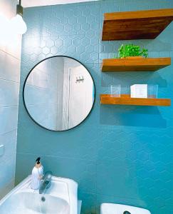 a blue bathroom with a mirror and a sink at The Intramuros Family Suite in Manila