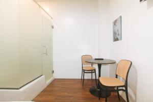 a table and chairs in a room with a hallway at GREN PLACE near Baclaran Airport Road by RedDoorz in Manila
