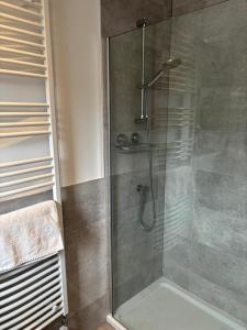 a shower with a glass door in a bathroom at Gorgeous Dornoch apartment in Dornoch