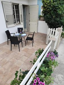 Un patio con mesa y sillas y flores. en Villetta nonna Pina, en Torre dell'Orso
