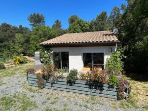 a small house with some plants in the yard at Gite Cocon entre lac et Nature in Carcassonne