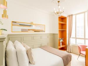 sypialnia z łóżkiem i żyrandolem w obiekcie Merveil - Luxury Suite - Louvre - Rousseau w Paryżu