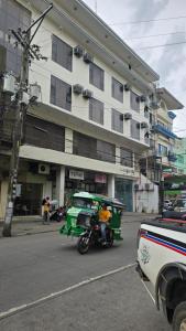Ein Motorrad und ein Auto parken vor einem Gebäude in der Unterkunft D'Luxe Suites in Lanquis