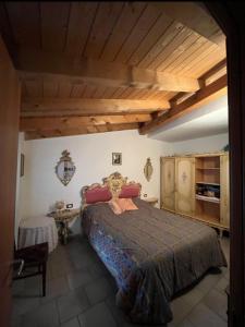 a bedroom with a large bed and a wooden ceiling at Casa montagna relax in Cedegolo