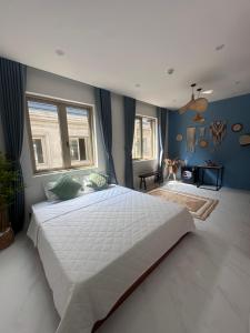 1 dormitorio con 1 cama blanca grande y paredes azules en Mây Tropic, en Dong Hoi