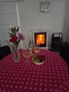 a table with a bowl of fruit and a bottle of wine at Apartament z kominkiem RetroGlam in Mieroszów