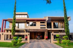 哈博罗内Escapade Lux Guesthouse的车道上停放着一辆汽车的房子