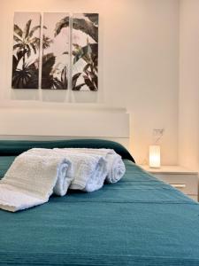 a bed with a towel sitting on top of it at Verdeacqua my villa in the pinewood in Spotorno