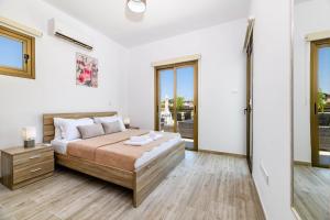 a bedroom with a large bed and a window at Kymma Villa #5 in Ayia Napa