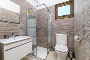 a bathroom with a toilet and a shower and a sink at Kymma Villa #5 in Ayia Napa +7 photos