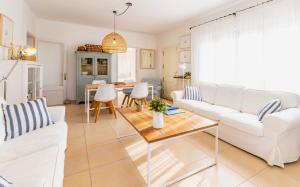 a living room with white furniture and a table at Casita Dragonera Sant Elm by Mallorca Infinity in Sant Elm