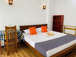 Walliwala Eastlahirus place的卧室里有一张带橙色枕头的床