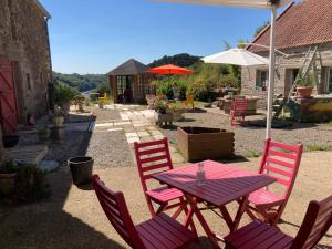 a picnic table with four chairs and an umbrella at Moulin des Baleines de Kérandraon Plouguerneau in Plouguerneau