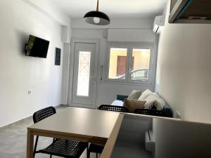 a living room with a table and chairs and a couch at Margie Town, Studio Αpartment in Zakynthos