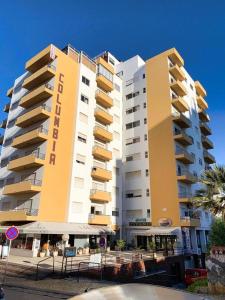 a large yellow and white building with a restaurant in front of it at T1 na 1 linha da Praia da Rocha in Portimão +21 photos