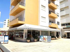 a store in front of a tall building at T1 na 1 linha da Praia da Rocha in Portimão