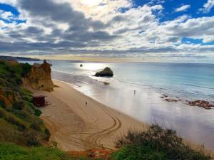 a beach with people on the sand and the ocean at T1 na 1 linha da Praia da Rocha in Portimão