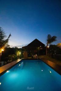 a large blue swimming pool at night at นาธาริเวอร์ไซด์ in Ban Lamphu La (3)