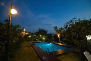 a swimming pool at night with a street light at นาธาริเวอร์ไซด์ in Ban Lamphu La (3) +7 photos