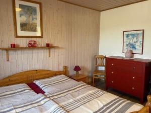 a bedroom with a bed and a dresser in it at Ostseebauernhof Schönhagen in Brodersby