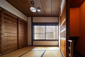 a hallway with wooden doors and a window at YADORU KYOTO HANARE Mizunoe No Yado in Kyoto +8 photos