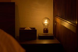 a light bulb sitting on a table next to a box at YADORU KYOTO HANARE Mizunoe No Yado in Kyoto