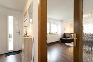 une porte ouverte sur un salon avec un canapé dans l'établissement Ferienhaus Freitag, à Kellenhusen
