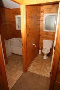 un baño con inodoro y bañera en Green Hayes Cottage, en Temuka