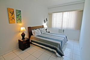 1 dormitorio con cama, lámpara y ventana en Rio Spot Homes vista mar D027, en Río de Janeiro