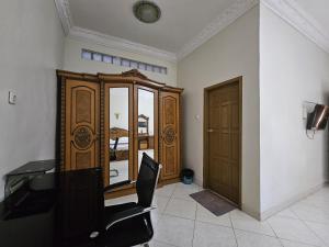 a room with a chair and a wooden cabinet at Flamboyan House in Padang +6 photos