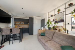 a living room with a couch and a kitchen at Penthouse FRANITA 50 meters from the beach in Kaštela