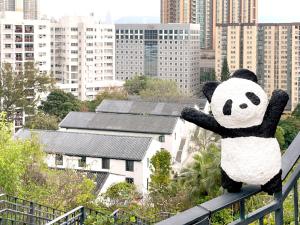 a stuffed panda bear sitting on top of a fence at 饒宗頤文化館 - 翠雅山房 in Hong Kong