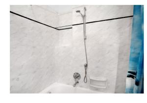 a shower in a white tiled bathroom at Casa del pescatore in Alassio +11 photos