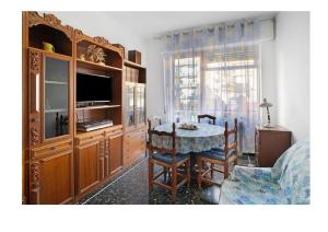 a living room with a dining room table and a television at Casa del pescatore in Alassio