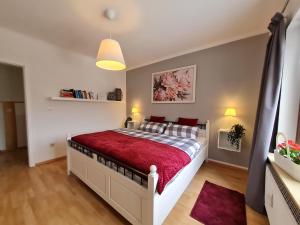 une chambre avec un grand lit avec une couverture rouge dans l'établissement Anjas Ferienwohnung in Syke-am Bahnhof, zentral aber ruhig, 2 Zimmer, Terrasse, Parkplatz, Bremen nur 25 km, à Syke